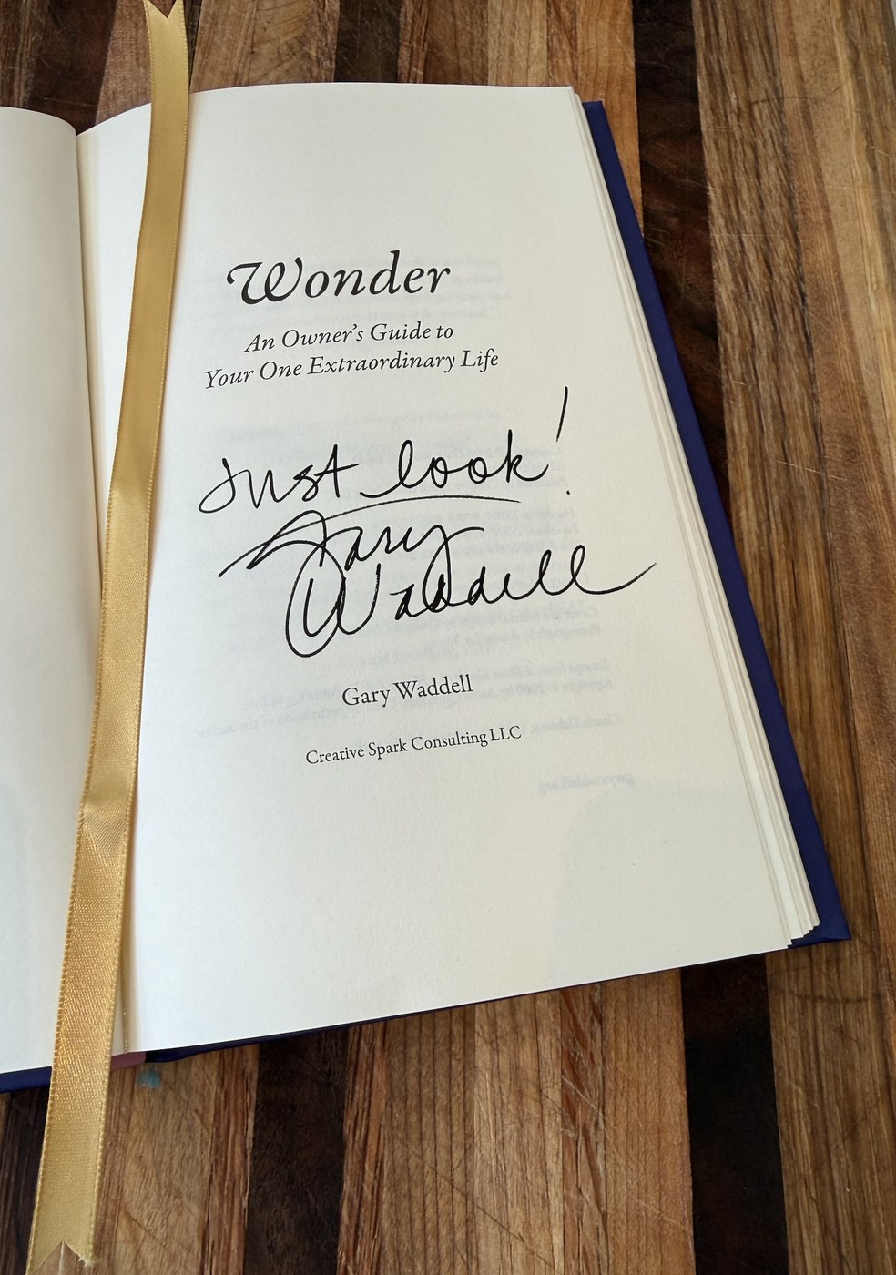 A signed hardcover of Wonder, inscribed 'Just look! Gary Waddell,' with a gold ribbon marker