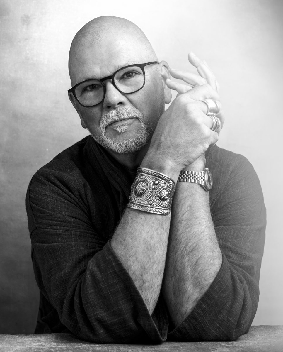 Gary Waddell, black and white portrait with hands clasped near his face, wearing an ornate cuff
